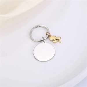 Detail of round stainless steel pendant with a golden sunflower charm keychain