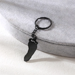 Porte-clés noir en acier inoxydable avec pendentif grand pied vu sous un angle de 45 degrés