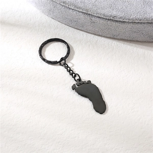 Porte-clés minimaliste en acier inoxydable noir avec empreinte sur fond blanc texturé