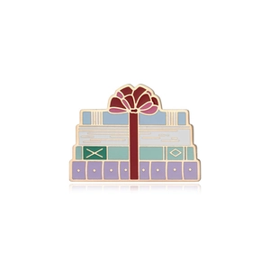 Macro shot of an enamel book pin with a red ribbon bow and four pastel colored books