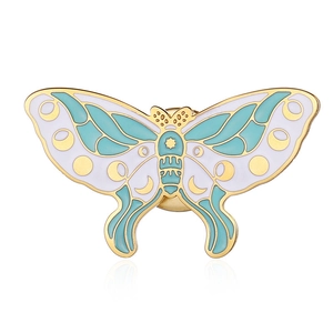 Detailed close-up of butterfly enamel pin with moon and star patterns on gold base