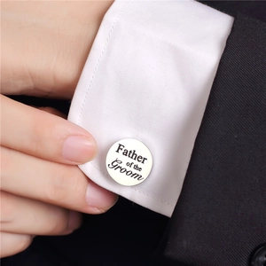 Macro detail of round Father of the Groom cufflinks on a white shirt and black suit