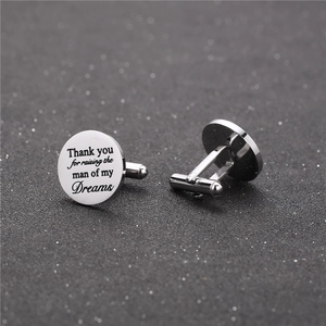Detailed macro view of silver steel cufflinks with Father of the Groom engraving