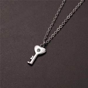 Detailed view of silver heart key pendant necklace with a sparkling center zircon