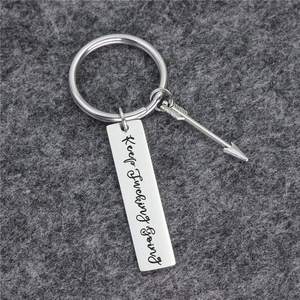 Inspirational Keep Fucking Going silver steel keychain with arrow charm on grey felt