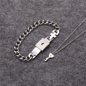 Detail of silver titanium steel set with heart key pendant necklace and lock bracelet