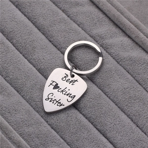 Silver guitar pick keychain engraved with Best Focking Sister on velvet background