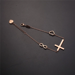 Dettaglio del bracciale in oro rosa con ciondoli infinito e croce e catena a cuore