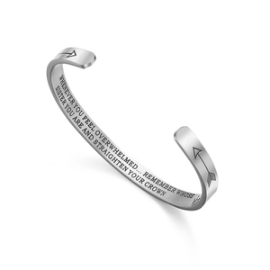 Detail of engraved inspirational quote on polished stainless steel open cuff bracelet