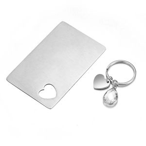 Macro view of stainless steel heart cutout card and keychain set with water drop pendant