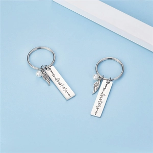 Porte-clés Soul Sisters en acier inoxydable avec pendentif aile et perle blanche élégant