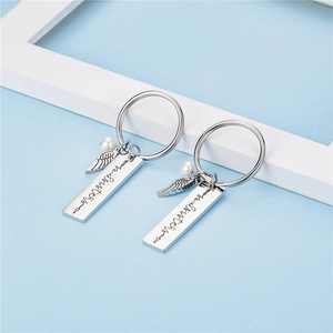 Porte-clés Soul sisters en acier avec pendentifs ailes et perles sur fond bleu clair