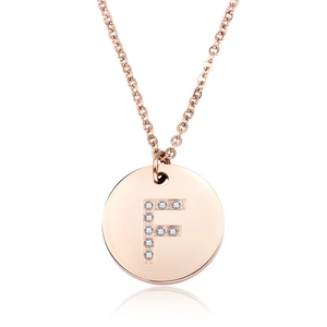 Dettaglio del ciondolo a moneta lettera F in oro rosa con pavé di micro cristalli