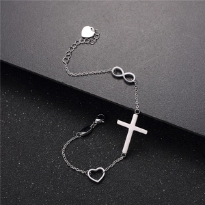 Bracciale in acciaio argento con croce bianca, simbolo infinito e ciondoli a cuore su fondo scuro