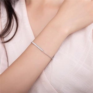 Minimalist silver chain bracelet with shimmering pave bar pendant worn on a model's wrist