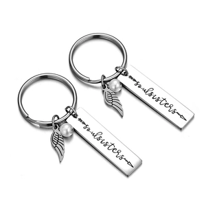 Porte-clés Soul Sisters en acier inoxydable avec pendentif aile et perle sur blanc