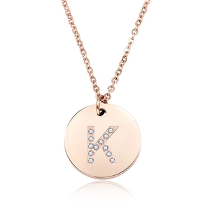 Dettaglio macro del ciondolo in oro rosa con lettera K impreziosita da diamanti lucidi