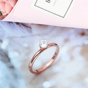 Close-up van roségoudkleurige titanium ring met ronde zirkoon in een klauwzetting