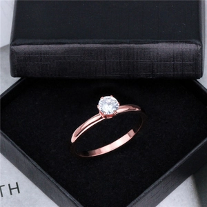 Macro detail van roségouden ring met zes-klauw gezette ronde diamant in een geschenkdoos