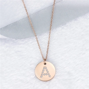 Collana in oro rosa con ciondolo a lettera A e cristalli su sfondo di pelliccia