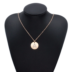 Collana in acciaio oro rosa con ciondolo a lettera A in cristallo su busto da esposizione