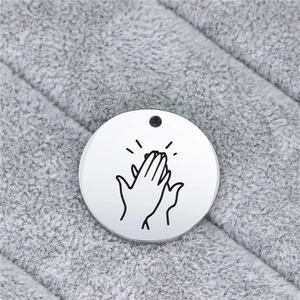 Creative stainless steel round pendant with engraved hand gesture sign on velvet background