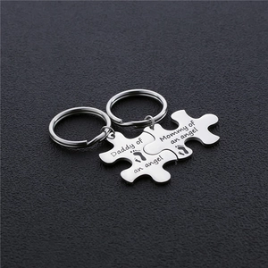 Polished puzzle piece keychains engraved with Daddy and Mommy of an angel text