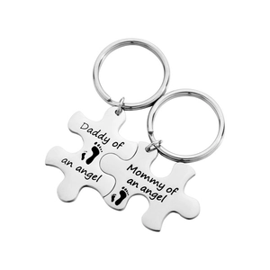 Silver puzzle piece keychains engraved with Daddy and Mommy of an angel text