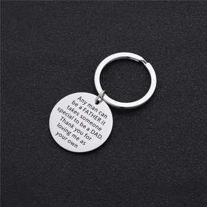 Polished stainless steel keychain with laser-engraved fatherhood quote on black texture