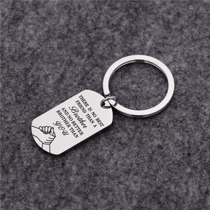 Detail of engraved stainless steel keychain with brotherhood quote and hand-holding graphic