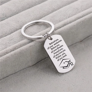 Detailed close-up of engraved stainless steel keychain with graduation quote in velvet box