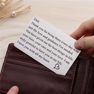Father's Day gift card in brushed steel being placed into a brown leather wallet