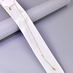 Detalle de la tobillera de cadena con bolas en oro rosa con extensión y placa de logo