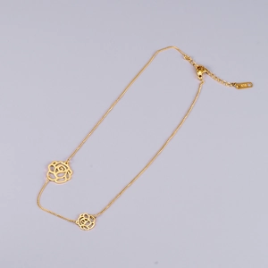 Elegant 18K gold-plated choker necklace with hollow rose flower charms on a purple background
