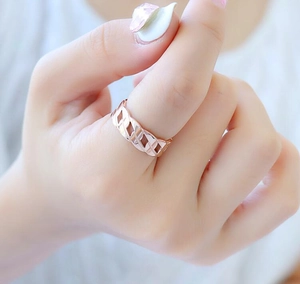 Detailed view of wide hollow mesh ring in 18K rose gold finish on hand