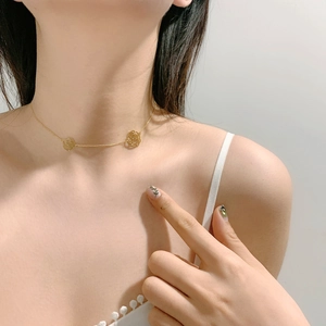 Close-up of elegant hollow camellia flower pendant on golden titanium steel chain