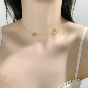Detailed view of elegant gold hollow camellia pendant necklace worn on the collarbone