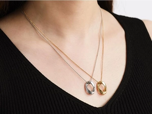 Minimalistische gedrehte ovale Halskette in Gold und Silber auf einem Model