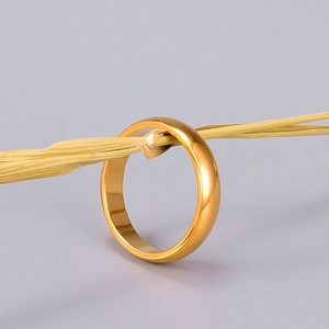 Makroaufnahme des breiten goldbeschichteten minimalistischen Rings auf Dekostroh