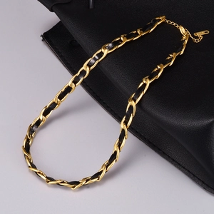 Dettaglio ravvicinato della catena vintage placcata oro 18K e della pelle intrecciata