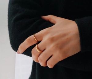 Nahaufnahme von minimalistischen 18K vergoldeten breiten und dünnen Ringen am Finger