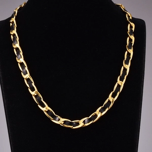 Dettaglio catena chunky placcata oro 18K intrecciata con pelle nera su manichino