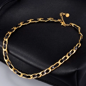 Dettaglio della catena in acciaio placcato oro 18K intrecciata con pelle nera e ciondolo K18