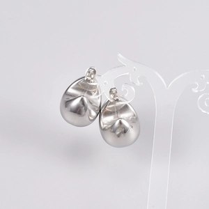 Polished silver hollow teardrop stud earrings in French retro style on a display stand