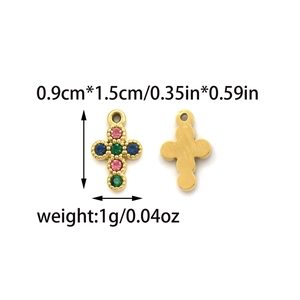 Pendentif croix en acier doré serti de zircons colorés sur fond blanc impeccable