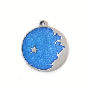 Detailed macro of a round blue glitter pendant with star and moon charms for DIY jewelry