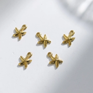Macro detail of five polished gold starfish charms for DIY jewelry making accessories
