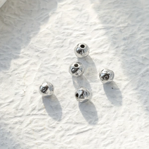 Macro shot of silver stainless steel spacer beads with unique crinkle texture for DIY jewelry