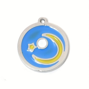Detail of round celestial pendant with yellow moon and stars over a blue enamel finish