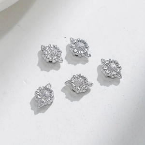 Macro shot of silver sunflower-shaped stainless steel spacer beads for DIY jewelry making